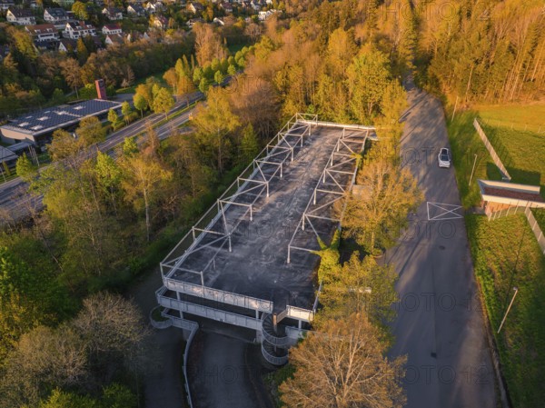 Empty car park surrounded by dense trees and a road in the evening light, rural atmosphere, Nagold, district of Calw, Germany, Europe