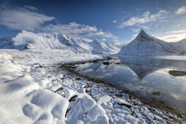 Snowy landscape with mountains and fjord, Volandstinden mountain, Fredvang, Flakstadøya, Lofoten, Norway, Europe