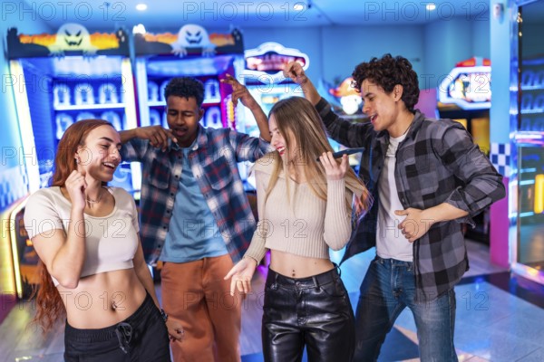 Four multi ethnic friends singing karaoke and dancing, enjoying their weekend together in a vibrant arcade