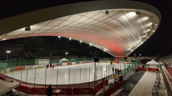 Tourists on ice rink, ice sports stadium, ice skating in the evening, Schierker Feuerstein Arena, Graft Architekten, Schierke, Wernigerode, Harz National Park, Saxony-Anhalt, Germany, Europe