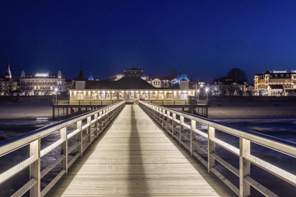 Restaurant on Ahlbeck Pier, Seebrücke Ahlbeck illuminated at dusk in the Baltic Sea on Usedom island, Mecklenburg-Vorpommern, oldest pier in Germany