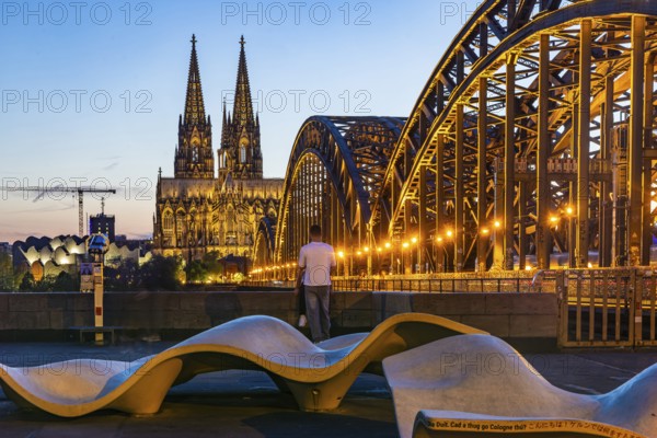 New seating on Norbert-Burger-Platz at the end of the Hohenzollern Bridge on the right bank of the Rhine. Inscription in various languages: What do you want in Cologne? City view with Cologne Cathedral. Cologne, North Rhine-Westphalia, Germany, Europe