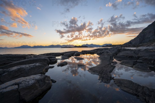 Clouds reflected in a small pond on a rocky coast, coastal landscape at sunset, Henningsvær, Lofoten, Nordland, Norway, Europe