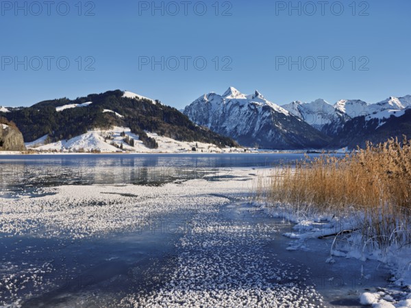 Frozen Sihlsee, reservoir, behind the snow-covered mountains Flübrig and Druesberg, Euthal, Canton Schwyz, Switzerland, Europe