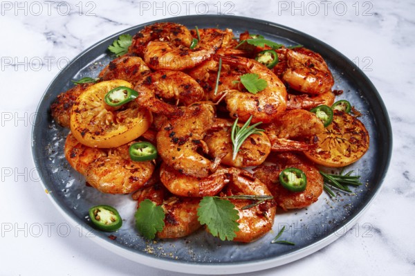 Grilled shrimp, unpeeled, headless, with spices, on a marble table, homemade, no people