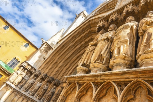 Ancient statues decorating the entrance of tarragona cathedral in spain, showcasing architectural details under a blue sky
