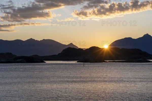 Sun setting behind Bergen, coastal landscape at sunset, Henningsvær, Lofoten, Nordland, Norway, Europe