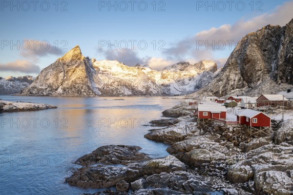Rorbuer fishing huts in front of snow-covered mountains in winter, Hamnøy, Moskenesøy, Lofoten, Norway, Europe