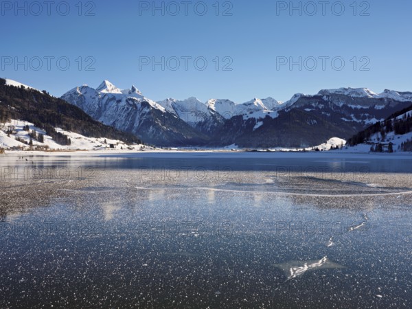 Frozen Sihlsee, reservoir, behind the snow-covered mountains Flübrig and Druesberg, Euthal, Canton Schwyz, Switzerland, Europe