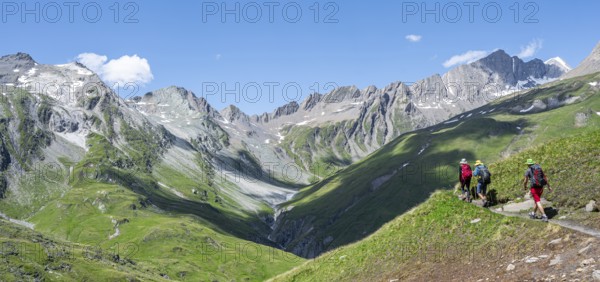 Three mountaineers on a hiking trail on the Daberlenke, view of rocky mountain peaks in the Karbachtal valley with Tredebergspitze, Lasörling Höhenweg, Lasörlinggruppe, Hohe Tauern National Park, East Tyrol, Tyrol, Austria, Europe