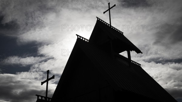 The silhouette of a church with several crosses against a cloudy sky, backdrop Kristin Lavranstochter film, Jørundgard Middelaldersenter, Olavsweg or Olavsleden, Sel municipality, Gudbrandsdalen, Norway, Europe