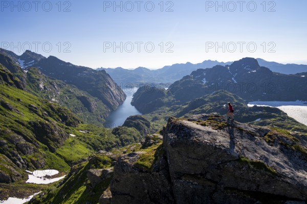 Mountaineer, young woman in front of mountain landscape, fjord Trollfjord and mountains, hike to Trollfjord Hytta, at Trollfjord and Raftsund, Lofoten, Nordland, Norway, Europe