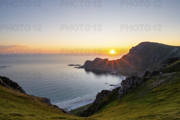View of coastal landscape at sunset, cliffs and summit of Måtind or Måtinden, Høyvika beach and sea, Andøya island, Vesterålen, Nordland Norway