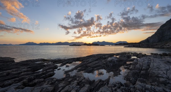 Clouds reflected in a small pond on a rocky coast, coastal landscape at sunset, Henningsvær, Lofoten, Nordland, Norway, Europe