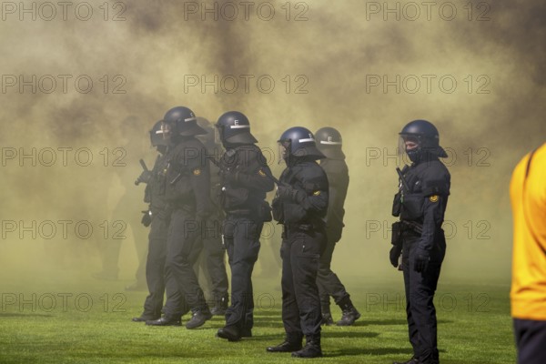 Football 3rd division, 2024/25 season, matchday 37: Waldhof Mannheim v Dynamo Dresden***Police officers control the situation on the pitch amid billows of smoke from pyrotechnics