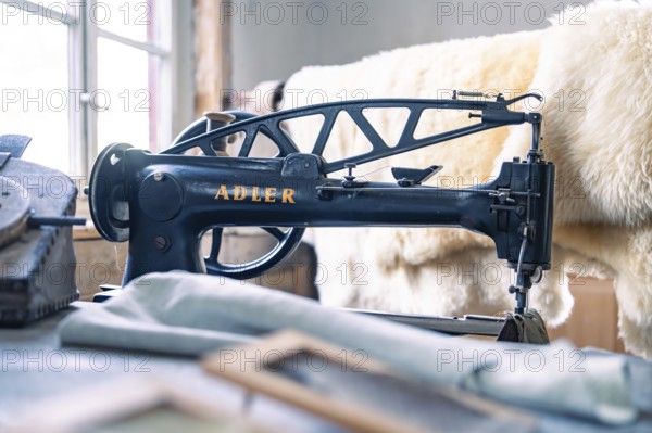 An antique Adler sewing machine in a studio with sewing accessories and leather material, Calw Tannery Museum, Black Forest, Germany, Europe