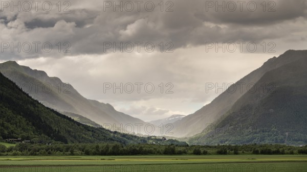 Impressive mountain landscape with dramatic sky, low-hanging rain clouds and play of light in the valley, Sel municipality, Gudbrandsdalen, Norway, Europe