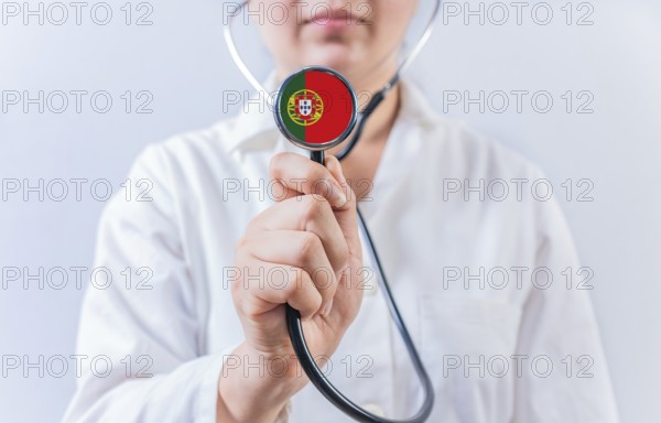 Female doctor holding stethoscope with Portugal flag. National health system of Portugal