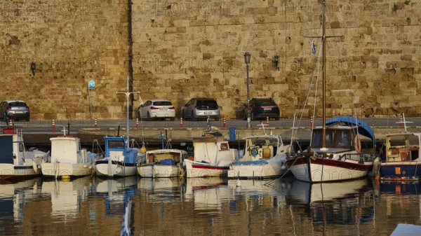 Boats and cars in front of a stone wall, with reflections in the water, harbour area, Rhodes Town, Rhodes, Dodecanese, Greek Islands, Greece, Europe