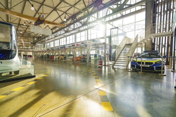 Hall with glass garage full of cars, direct sunlight and modern architecture, Motorworld Böblingen, Germany, Europe