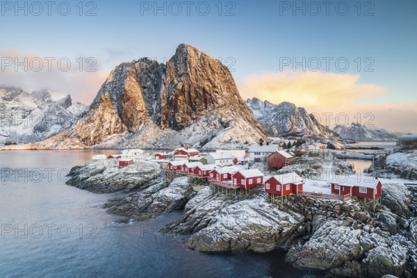 Rorbuer fishing huts in front of snow-covered mountains in winter, Hamnøy, Moskenesøy, Lofoten, Norway, Europe