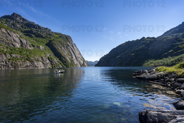 Motorboat with tourists in the fjord Trollfjord, mountains reflected in the water, fjord landscape and mountains, Lofoten, Nordland, Norway, Europe