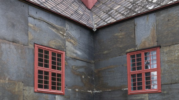 Detailed view of a corner of a building with red window frames on slate-clad walls, Dovre church, Dovre kyrkje, Dovre, Fylke Innlandet, upper Gudbrandsdalen, Norway, Europe