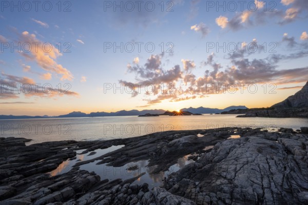 Clouds reflected in a small pond on a rocky coast, coastal landscape at sunset, Henningsvær, Lofoten, Nordland, Norway, Europe