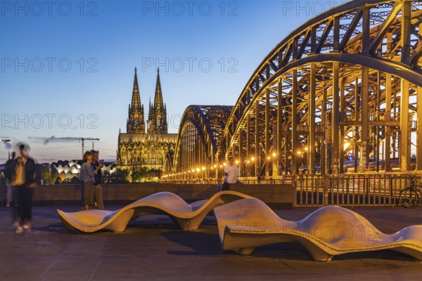 New seating on Norbert-Burger-Platz at the end of the Hohenzollern Bridge on the right bank of the Rhine. Inscription in various languages: What do you want in Cologne? City view with Cologne Cathedral. Cologne, North Rhine-Westphalia, Germany, Europe