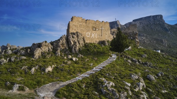 Drone shot, stone ruin on hill with paved path in mountainous landscape under blue sky, Archangelos, castle, place, castle of Archangelos, Rhodes, Dodecanese, Greek Islands, Greece, Europe