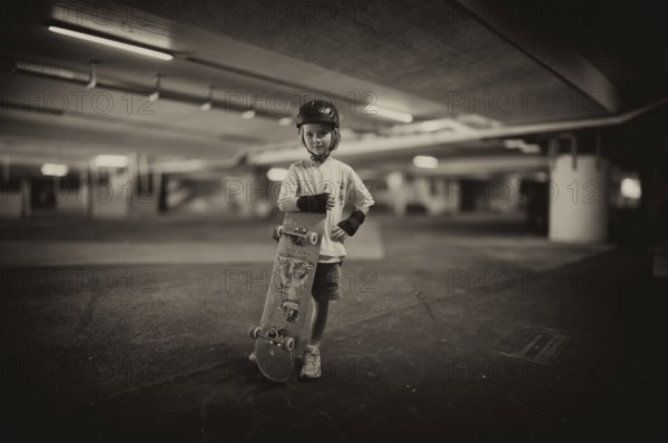 Boy, blonde, 6 years, posing with skateboard, crash helmet, protective clothing, subway, urban, concrete, black and white, Stuttgart, Baden-Württemberg, Germany, Europe