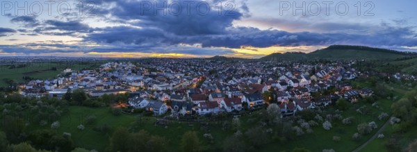 City lights at dusk with hills and dense clouds in the sky, Korb-Steinreinach, Rems Valley, Baden-Württemberg, Germany, Europe