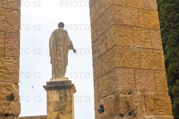 Ancient roman statue standing tall amidst the ruins of tarragona, showcasing the city's rich historical heritage