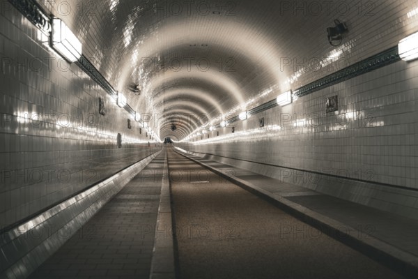 Symmetrically illuminated tiled tunnel with curved lines and depth, old Elbe tunnel, Hamburg, Germany, Europe