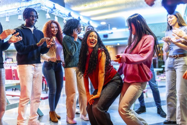 Young diverse friends dancing and having fun at a bowling alley, enjoying their weekend together with music and entertainment
