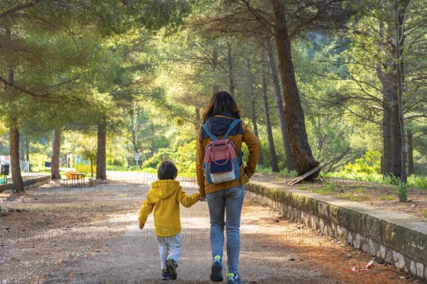 Mother and son enjoying a peaceful walk through the natural beauty of la fontcalda, a sanctuary nestled in gandesa, tarragona