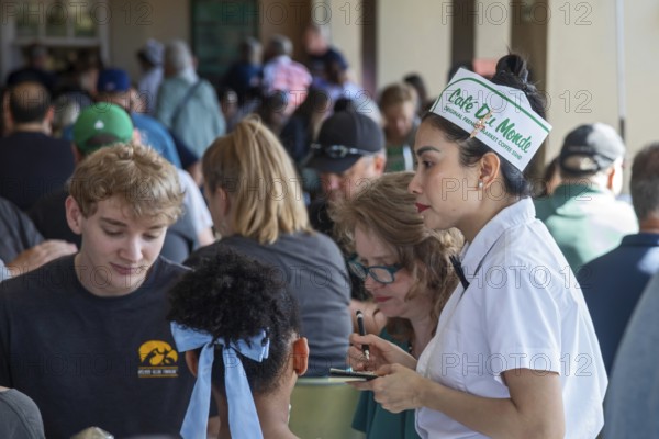 New Orleans, Louisiana - A server takes orders at Cafe du Monde. The coffee shop in the French Market is extremely popular because of its beignets, which are loaded with powdered sugar