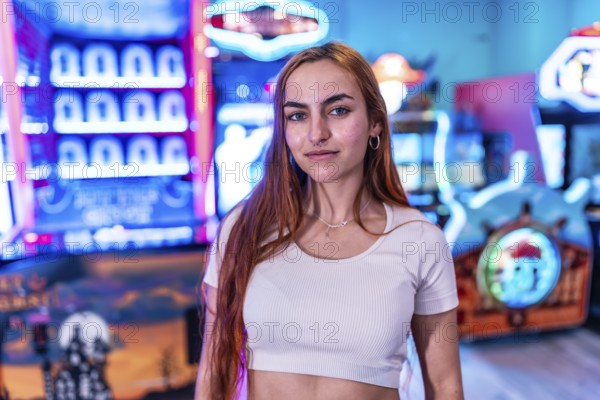 Stylish young woman standing in a vibrant amusement arcade, surrounded by colorful neon lights and various gaming machines