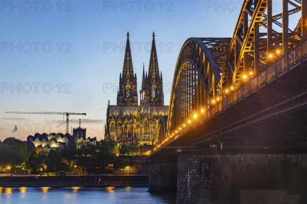 Cologne Cathedral, illuminated in the evening. Hohenzollern Bridge, railway bridge over the Rhine. City view of Cologne, North Rhine-Westphalia, Germany, Europe