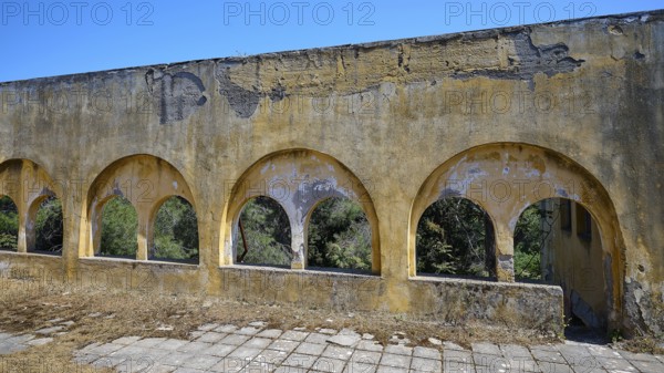 Dilapidated yellow arches in the exterior of a ruined building with visible structural damage, Lost Place, Former Santorium, Tuberculosis Centre 1947-1970, Former Italian colonial settlement, Eleousa, Campochiaro, Rhodes, Dodecanese, Greek Islands, Greece, Europe