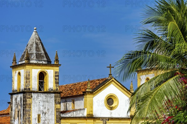 Beautiful baroque church tower amidst the vegetation of the city of Olinda with the sea in the background, Olinda, Pernambuco, Brazil, South America