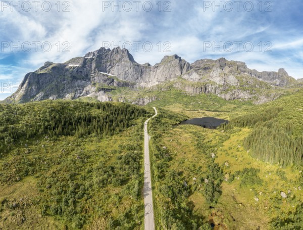 Panoramic aerial view of road in mountain scenery, passing lakes and meadows, road from E10 to village Nusfjord, Lofoten, Norway, Europe