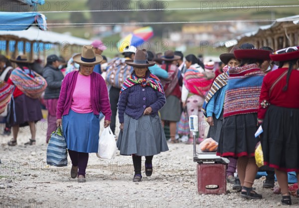 Peruvian woman with traditional skirts and hats at the indigenous market in Chinchero, Cusco region, Peru, South America