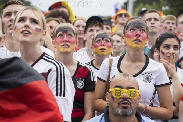 Women wearing make-up in the German national colours watch the football match in the fan zone at the Brandenburg Tor during the quarter-final match between Germany and Spain at the European Football Championship, Berlin, 05.07.2024
