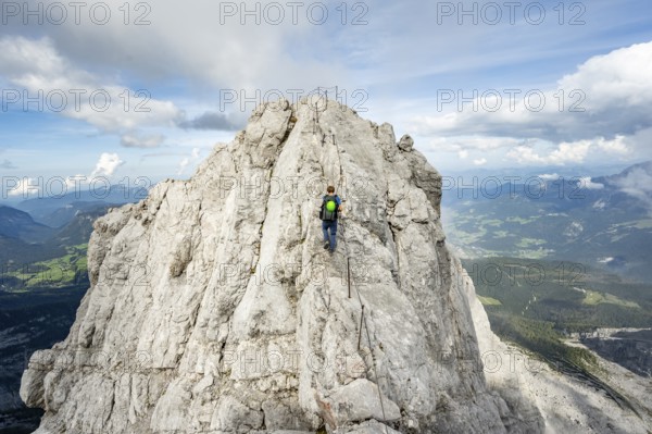 Mountaineer on a narrow rocky ridge on a steel cable, Watzmann crossing to Watzmann Mittelspitze, view of mountain panorama, Berchtesgaden National Park, Berchtesgaden Alps, Bavaria, Germany, Europe