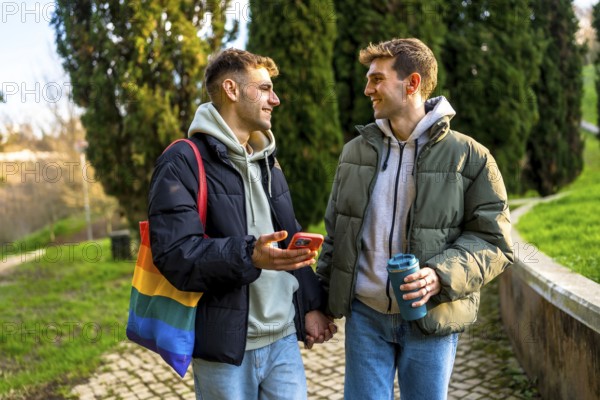 Happy gay couple holding hands and walking in a park, enjoying a relaxing day together and showing love and support for lgbtq plus community