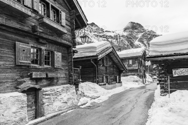 Street with historic old snow-covered wooden houses, black and white photo, mountain village Zinal, Val d'Anniviers, Valais Alps, Canton Valais, Switzerland, Europe