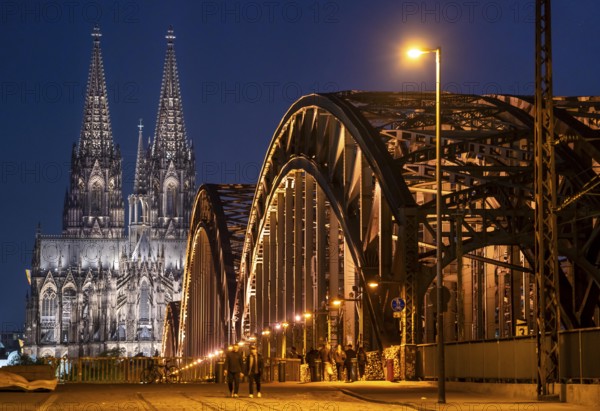Cologne Cathedral, has been shining in new light since Easter 2025, the old metal halide lamps have been replaced by over 700 modern LED lamps, reducing energy consumption by around four fifths, significantly improving the quality of light and greatly reducing light emissions, 12 KM of new cables were laid for this, Hohenzollern Bridge, railway bridge over the Rhine, North Rhine-Westphalia, Germany, Europe