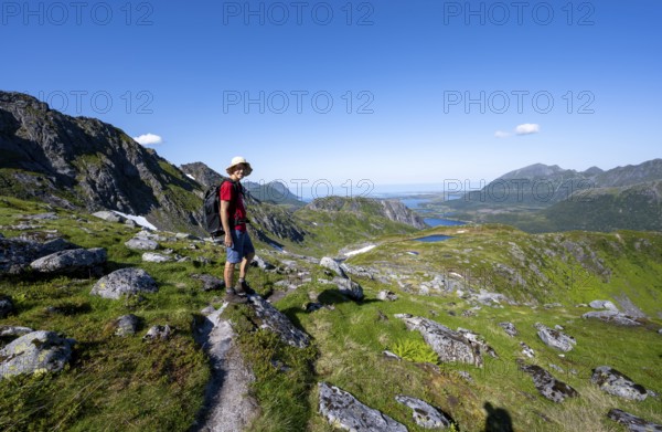 View of mountains and fjord landscape, mountaineer on hiking trail to the summit of Rundfjellet, Svolvaer, Nordland, Norway, Europe