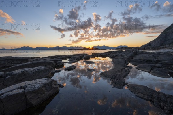 Clouds reflected in a small pond on a rocky coast, coastal landscape at sunset, Henningsvær, Lofoten, Nordland, Norway, Europe